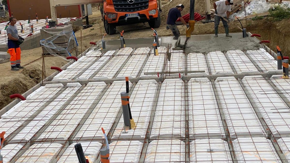Coulage d'une dalle à la pompe à béton sur un plancher hourdis armé, trois compagnons au tirage