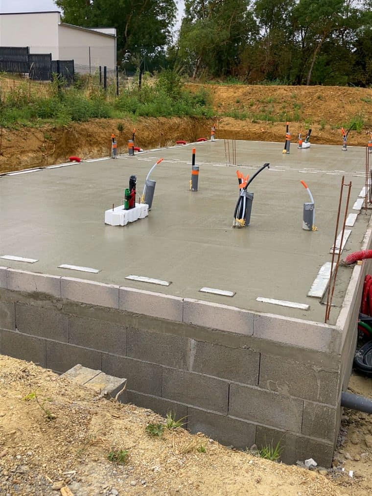 Dalle béton talochée coulée sur un soubassement en parpaings, réservations de réseaux en attente