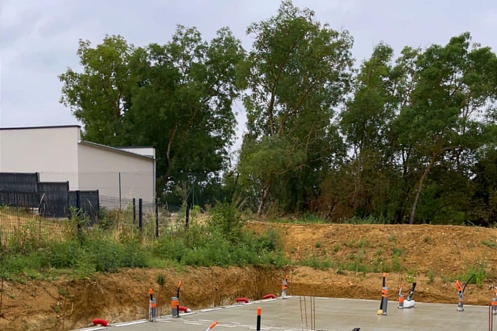Dalle béton talochée coulée sur un soubassement en parpaings, réservations de réseaux en attente