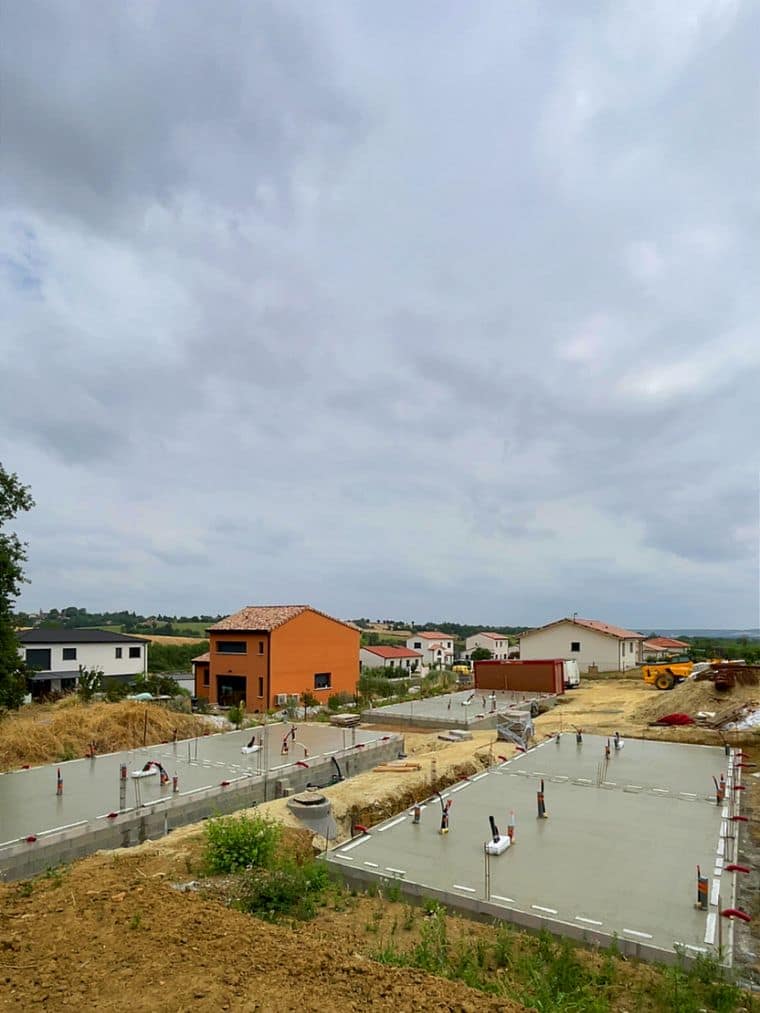 Deux dalles coulées sur soubassement, vue d’ensemble d’un chantier de lotissement en coteau