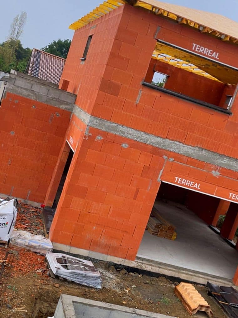 Élévation R+1 en brique, linteaux préfabriqués posés au-dessus de l’ouverture de garage et chaînage horizontal apparent