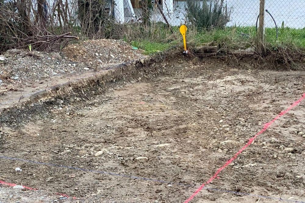 Terrain décapé et implantation tracée au cordeau avant ouverture des fouilles