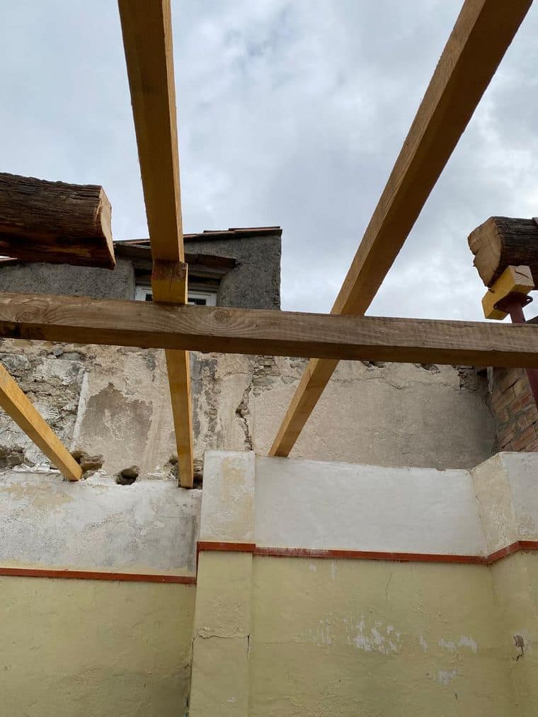 Têtes de murs anciens en moellons et brique, nouvelles pièces de bois posées en appui sur étais