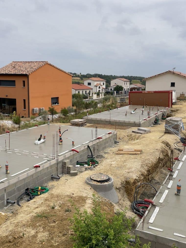 Dalles achevées et tranchée de réseaux avec regard béton entre deux lots