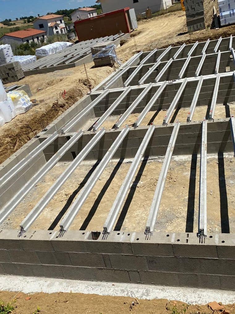Soubassement en blocs terminé, poutrelles béton posées pour un plancher sur vide sanitaire