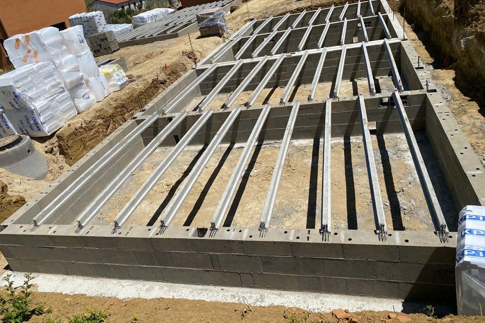 Soubassement en blocs terminé, poutrelles béton posées pour un plancher sur vide sanitaire